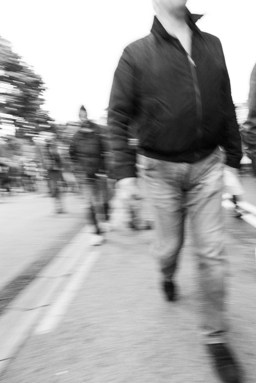 Dangerous group of people walking towards the camera eye. Demonstration. Converted to black and white, grain added.