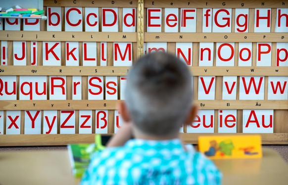 ARCHIV - 08.08.2016, Dresden: Ein Kind sitzt vor einer Tafel mit Buchstaben. Unter Viertkl�sslern in Deutschland gibt es einer Studie zufolge beim Wortschatz erhebliche Unterschiede. Zu diesem Ergebni ...