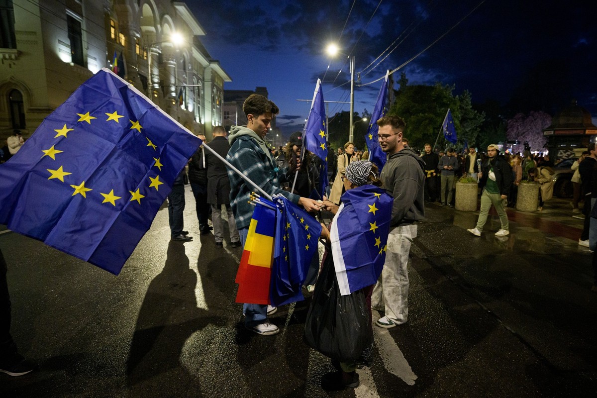 A woman sells European Union and Romanian flags to supporters of presidential candidate Nicusor Dan after polls closed for the second round of the country&#039;s presidential election redo in Buchares ...