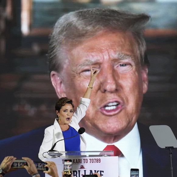 Republican candidate Kari Lake cheers along with supporters as former Republican President Donald Trump addresses the crowd with a video message endorsing Lake, as Lake announces her plans to run for  ...