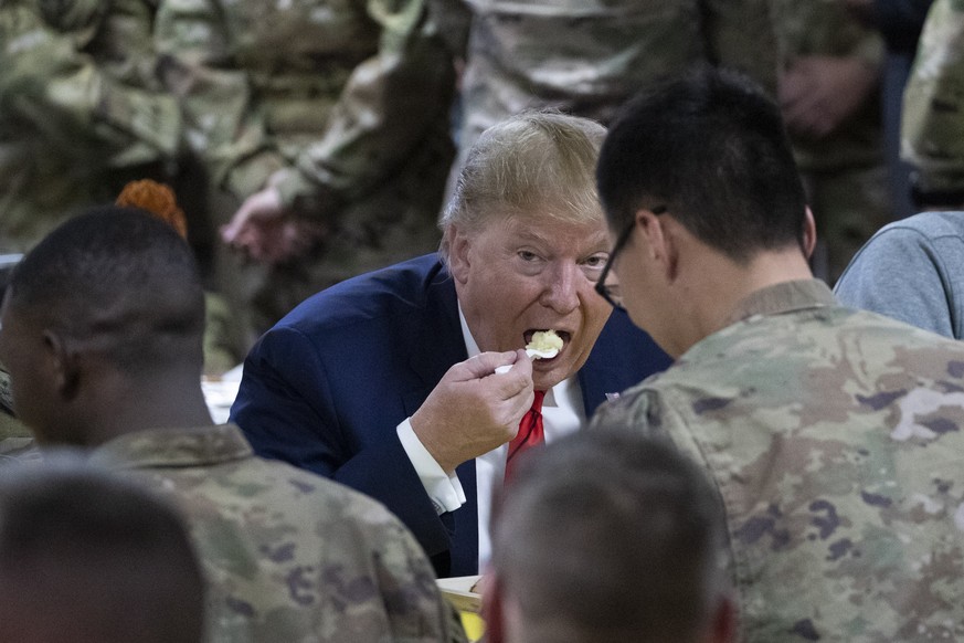 President Donald Trump eating with members of the military in a dining facility during a surprise Thanksgiving Day visit, Thursday, Nov. 28, 2019, at Bagram Air Field, Afghanistan. (AP Photo/Alex Bran ...