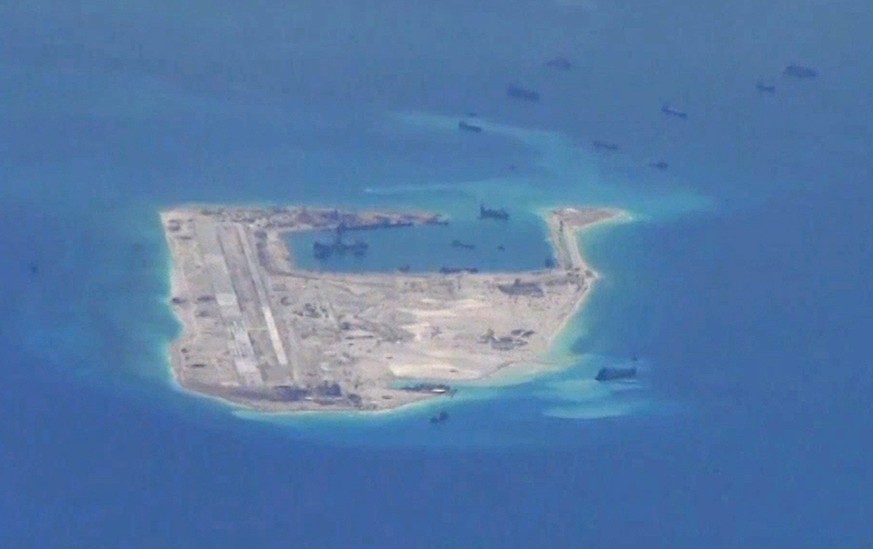 FILE PHOTO: Chinese dredging vessels are purportedly seen in the waters around Fiery Cross Reef in the disputed Spratly Islands in the South China Sea in this still image from video taken by a P-8A Po ...
