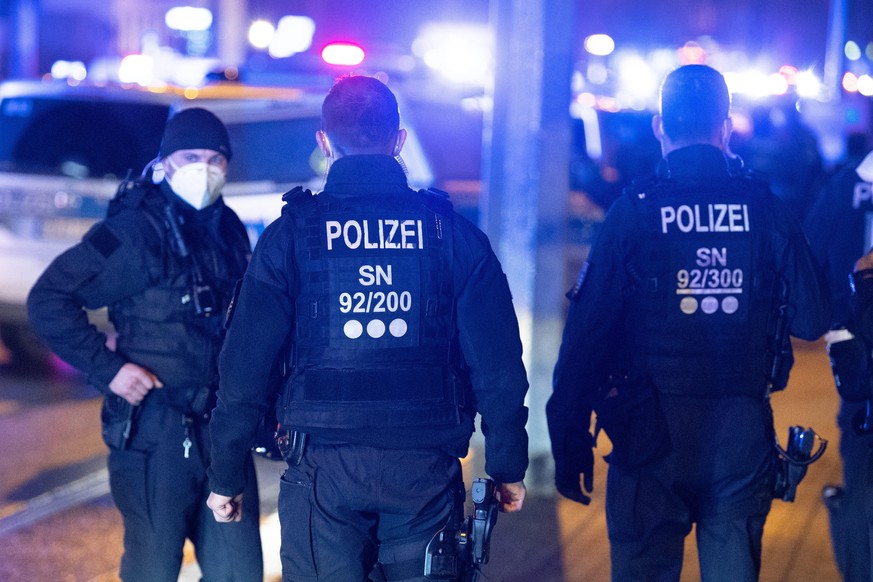 Polizisten stehen während eines Protest von Impfgegnern und Kritikern gegen die Corona-Maßnahmen im Dresdner Stadtteil Pieschen an einer Straße.