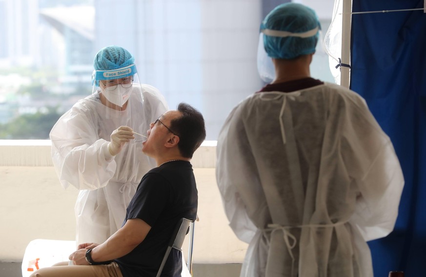 July 17, 2020, Hong Kong, China: A medical worker takes a sample from a taxi driver for COVID-19 testing, Rumsey Street Multi Storey Car Park in Sheung Wan. The government has offered taxi drivers fre ...