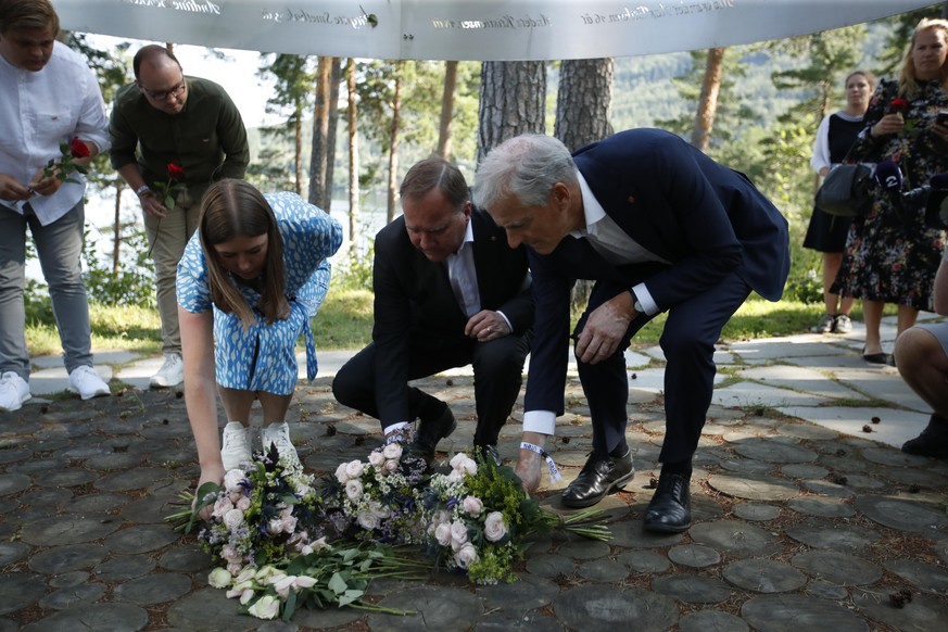 Geeint legen die Vorsitzende der AUF, Astrid Hoem, der Ministerpräsident von Schweden, Stefan Lövfen, der Vorsitzende der norwegischen Arbeiterpartei Jonas Gahr Store Blumen auf die Gedenkstette des Anschlags nieder.