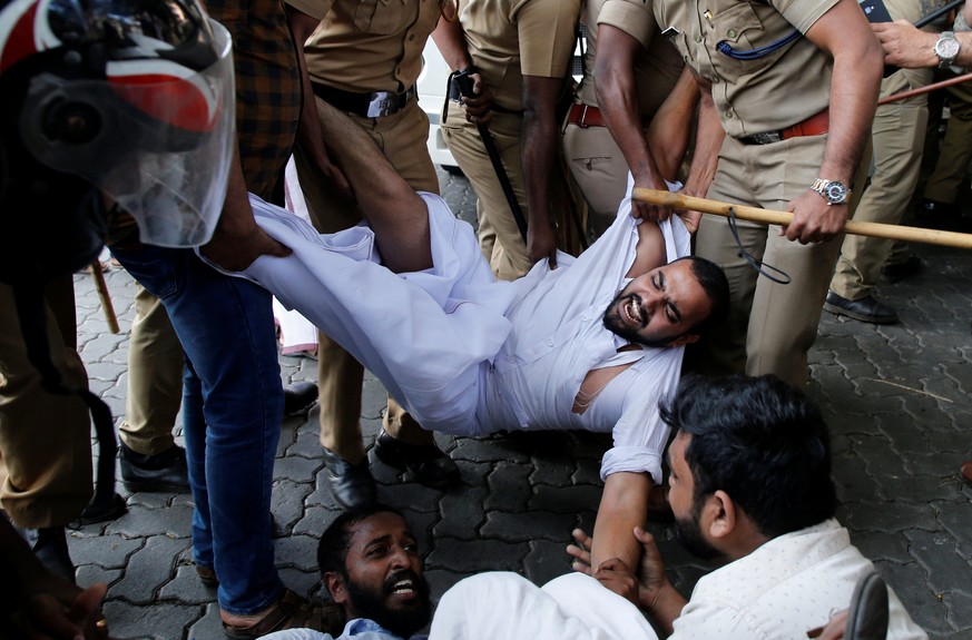 Police remove members of Kerala Students Union, the student wing of India's main opposition Congress party, as they take part in a protest after two women entered the Sabarimala temple, in Kochi, ...