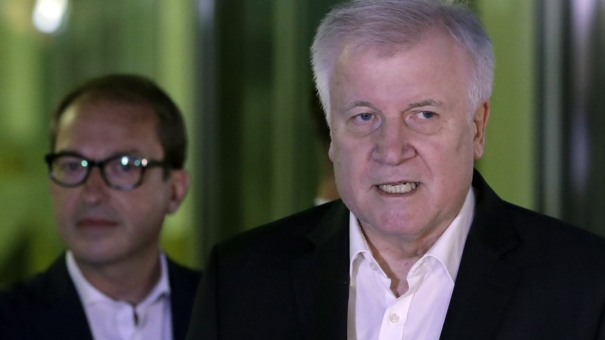 German Interior Minister and chairman of the German Christian Social Union (CDU), Horst Seehofer, right, addresses the media on the results of a meeting with German Chancellor and chairwoman of the Ge ...