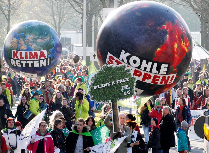 ARCHIV - 04.11.2017, Nordrhein-Westfalen, Bonn: Demonstranten fordern mit einem Modell der Erdkugel mit der Aufschrift &quot;Klima retten&quot; und einer weiteren mit der Aufschrift &quot;Kohle stoppe ...