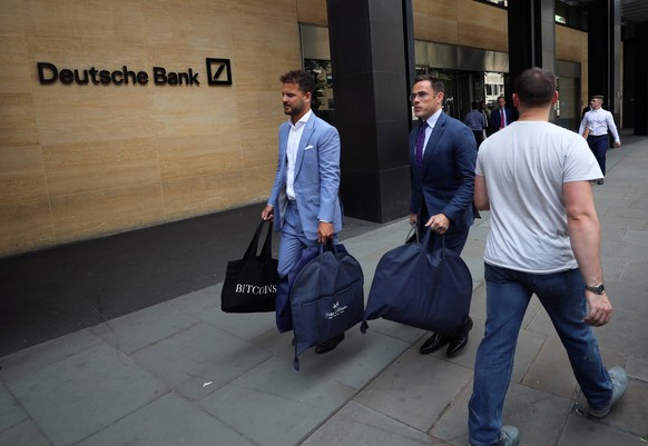 Banker verlassen die Deutsche Bank in London mit Maßanzügen.