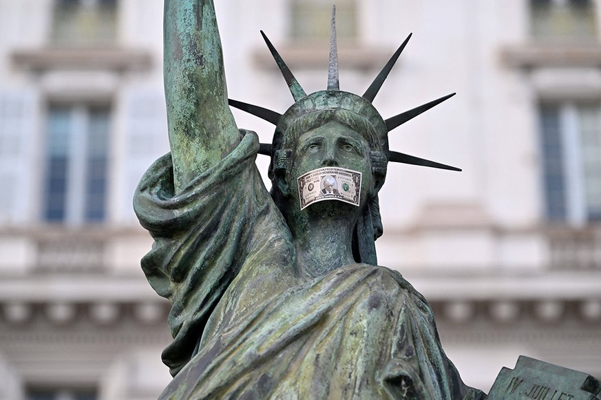 Replika der Freiheitsstatue in Nizza mit Dollarschein mit Trumpgesicht vor dem Mund.