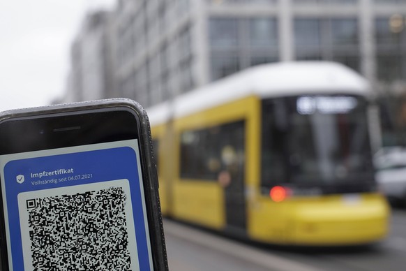 Symbolfoto Impfnachweis im oeffentlichen Nahverkehr Digitaler Impfnachweis neben Strassenbahn in Berlin, Symbolbild 2G, 3G Pflicht, Impfpflich fuer Corona Impfung im OEPNV, oeffentlichen Nahverkehr bz ...