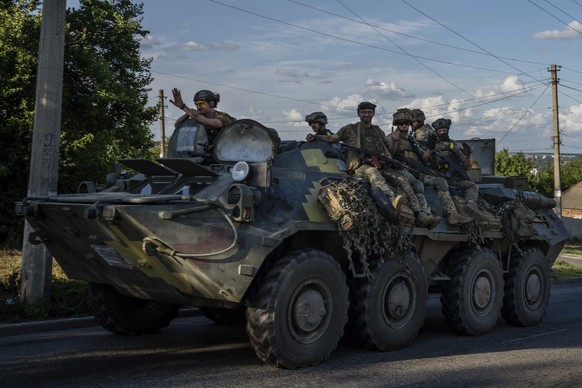 20.07.2022, Ukraine, Donezk: Ukrainische Soldaten fahren einen Panzer auf einer Stra
