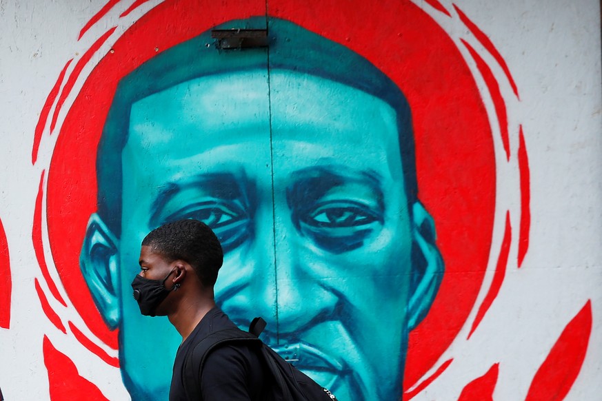 A man wearing a protective mask walks past a mural of George Floyd, in the aftermath of his death in Minneapolis police custody, in Chicago, Illinois, U.S., July 27, 2020. REUTERS/Shannon Stapleton