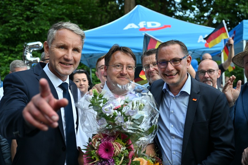 25.06.2023, Thüringen, Sonneberg: Björn Höcke, Vorsitzender der AfD Thüringen (l) und Tino Chrupalla, AfD-Bundesvorsitzender (r) gratulieren im Garten des Restaurants Frankenbaude dem Wahlsieger des T ...