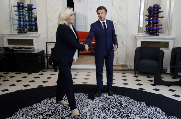 French President Emmanuel Macron, right, meets French far-right Rassemblement National (RN) leader and Member of Parliament Marine Le Pen at the Elysee Palace in Paris, France, Tuesday, June 21, 2022. ...