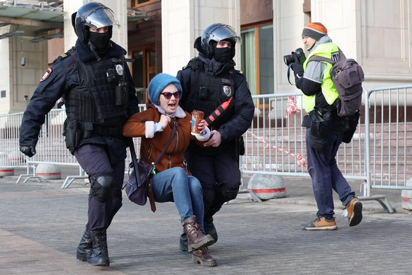 Russische Polizisten verhaften eine Demonstrantin bei einem Friedensprotest in Moskau.