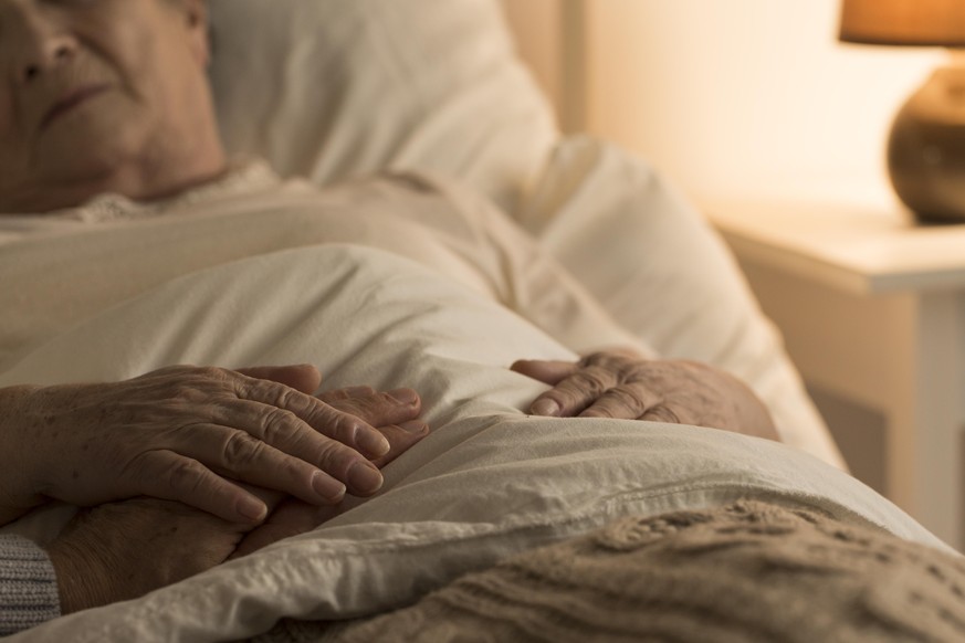 Close-up of hand of senior on hand of dying elderly person as sign of support during sickness