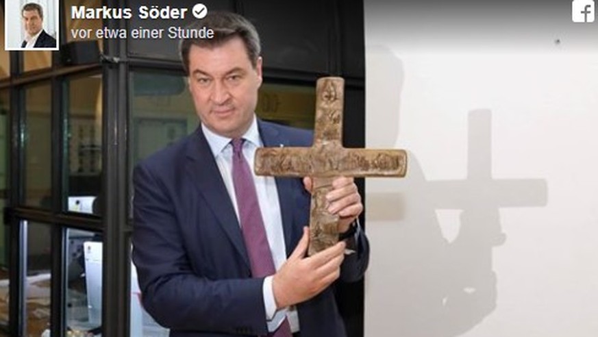Da ist das Ding. Markus Söder hängt nichtreligiöses Symbol an nichtreligiöse Wand.