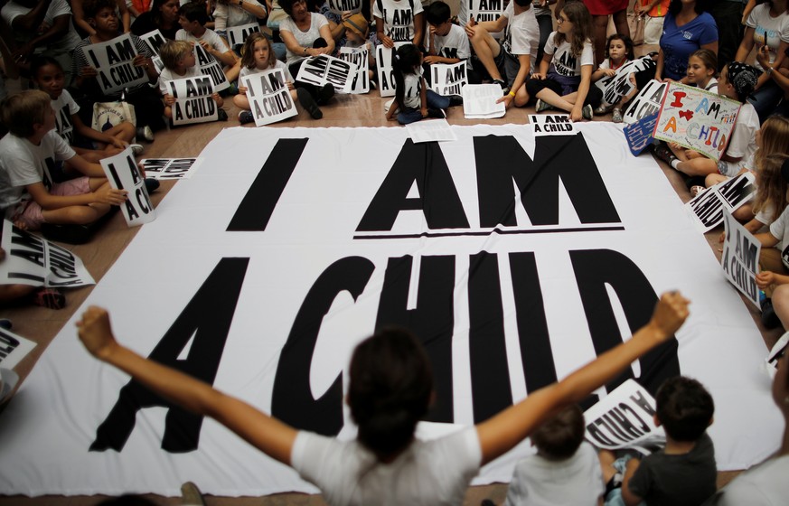 Children and family members take part in a sit-in following a march to mark “the court-ordered deadline for the Trump Administration to reunify thousands of families separated at the border, in Washin ...