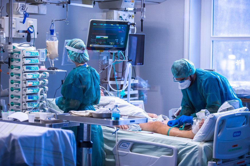 Ärzte und Pflegekräfte betreuen Patienten in einem der Behandlungszimmer der Intensivstation in der Universitätsmedizin Rostock. Angesichts der sprunghaft zunehmenden Zahl von Corona-Infizierten und d ...