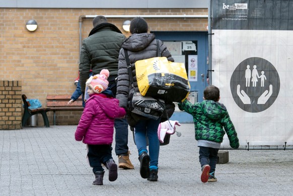 ARCHIV - 22.12.2022, Berlin: Ein Flüchtling geht mit seiner Familie auf dem Gelände der Erstaufnahmeeinrichtung des Landesamtes für Flüchtlingsangelegenheiten (LAF) in Reinickendorf. (zu dpa «Welche S ...