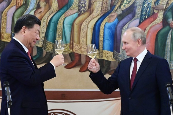 21.03.2023, Russland, Moskau: Der russische Präsident Wladimir Putin (r) und der chinesische Präsident Xi Jinping stoßen während ihres Abendessens im Facettenpalast an, einem Gebäude im Kreml. Putin u ...