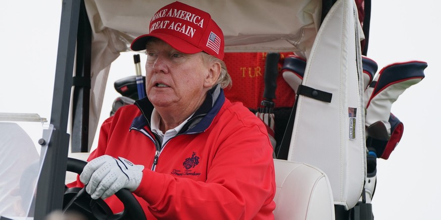 ARCHIV - 03.05.2023, Großbritannien, Turnberry: Donald Trump, ehemaliger Präsident der USA, fährt einen Golfwagen während seines Besuchs in Großbritannien auf seinem Golfplatz Trump Turnberry in South ...