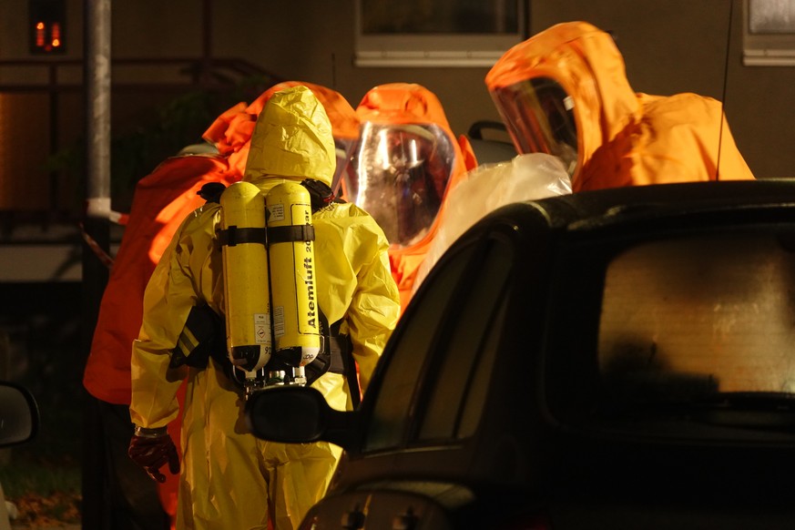 Feuerwehrleute sind in Schutzanzügen im Einsatz. Zwei Mitarbeiter des Paketdienstleisters Hermes in Haldensleben in Sachsen-Anhalt sind binnen eines Tages gestorben.