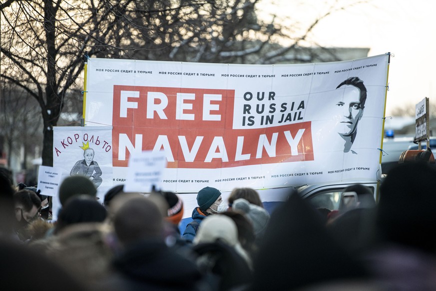31.01.2021, Berlin: Teilnehmer einer Demonstration, die eine Freilassung des russischen Oppositionellen Nawalny fordert, stehen mit einem Banner mit der Aufschrift