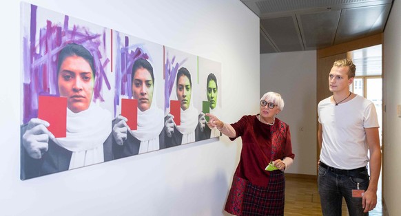 Claudia Roth vor dem Bild einer afghanischen Künstlerin, das vor ihrem Büro hängt.