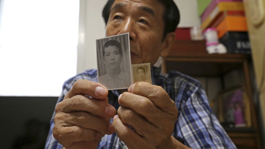In this Aug. 17, 2018, photo, Lee Soo-nam, 76, shows photos of his brother Ri Jong Song in North Korea during an interview at his home in Seoul, South Korea. Lee is among about 200 war-separated South ...