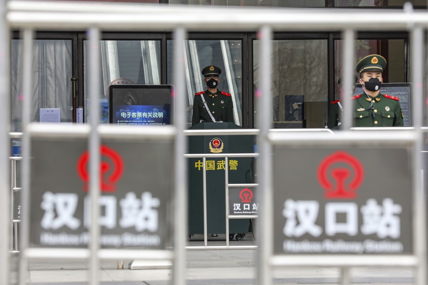 Soldaten der chinesischen paramilitärischen Polizei stehen mit Mundschutz vor dem geschlossenen Bahnhof Hankou.