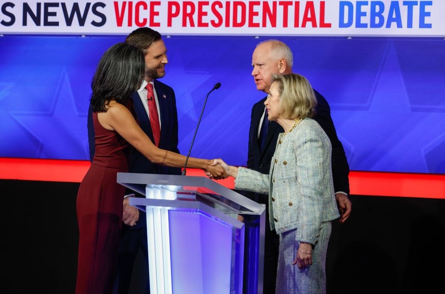 NEW YORK - OCTOBER 01: Democratic vice presidential nominee Minnesota Gov. Tim Walz and his wife Gwen Walz (R) speak with Republican vice presidential nominee Sen. JD Vance (R-OH) and his wife Usha Va ...