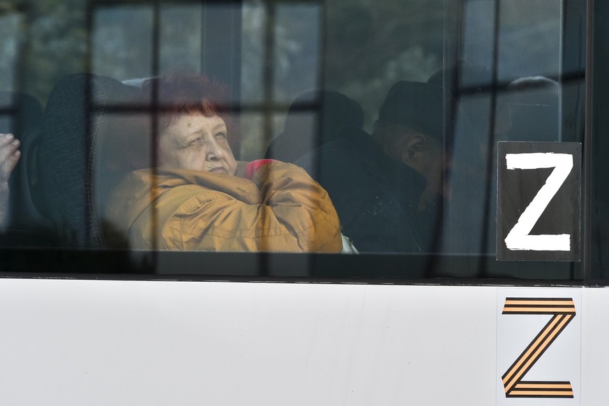 An elderly woman, an evacuee from Kherson, looks through a bus window decorated with the letters Z, which has become a symbol of the Russian military, at the railway station in Dzhankoi, Crimea, on We ...