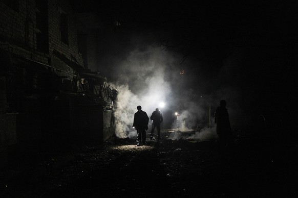 24.11.2022, Ukraine, Cherson: Anwohner gehen nach einem Angriff durch die Tr�mmer. Foto: Bernat Armangue/AP/dpa +++ dpa-Bildfunk +++