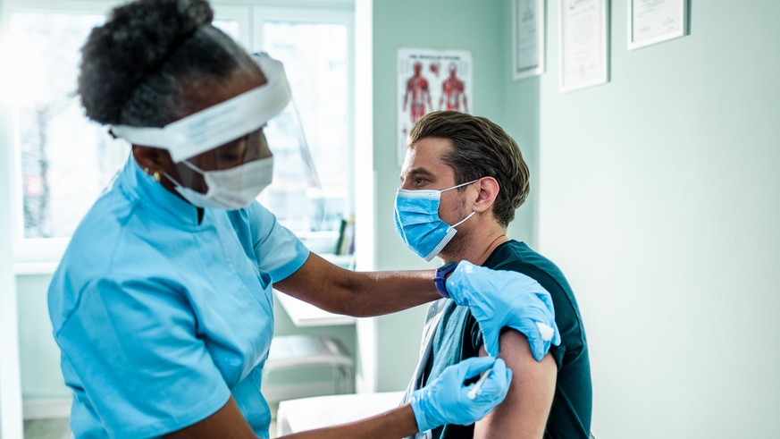 Close up of a young man getting vaccinated