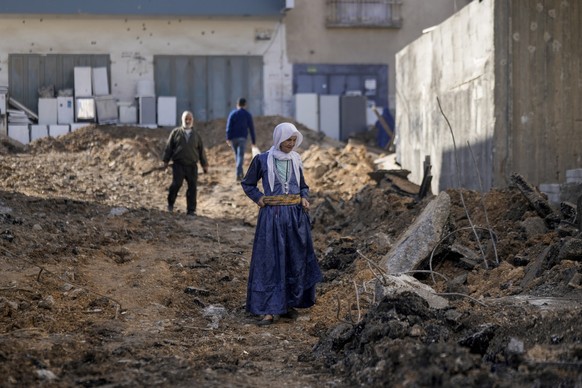 dpatopbilder - 17.11.2023, Palästinensische Gebiete, Dschenin: Palästinenser gehen auf einer durch einen israelischen Militärangriff beschädigten Straße im Westjordanland. Wie das palästinensische Ges ...