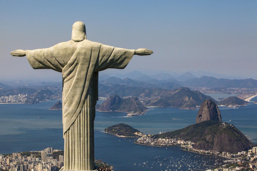 Aerial view from a helicopter of south of the Rio de Janeiro city with Cristo Redentor statue and the Sugarloaf mountain in the background in a beautiful day, Brazil