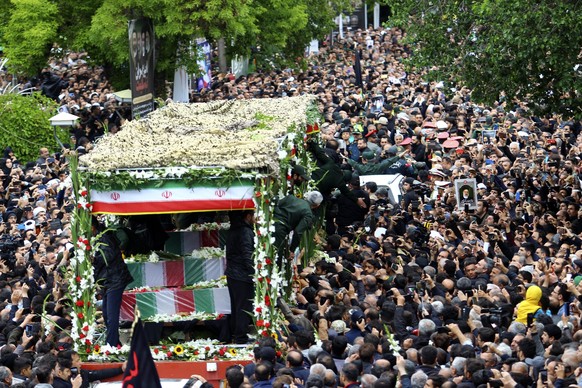 dpatopbilder - HANDOUT - 21.05.2024, Iran, Tabriz: Auf diesem von der Nachrichtenagentur Fars zur Verfügung gestellten Foto versammeln sich Trauernde um einen Lastwagen, der die Särge des iranischen P ...