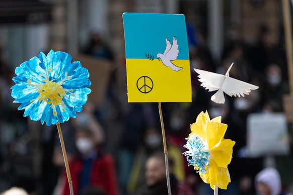 Schilder mit Friedenstaube und Blumen in den Farben der Ukraine werden hochgehalten. Unter dem Motto «Stoppt den Krieg! Frieden und Solidarität für die Menschen in der Ukraine» hatte ein breites Bündn ...