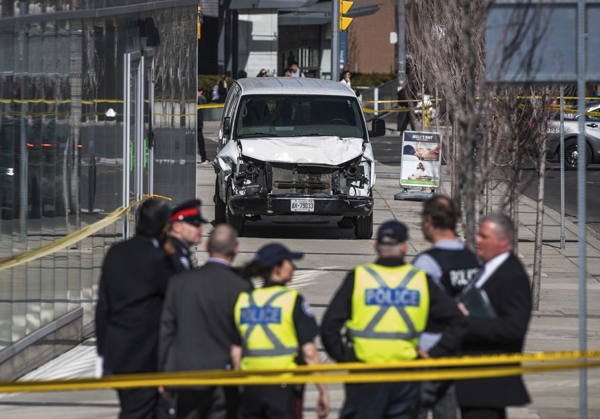 Police are seen near a damaged van after a van mounted a sidewalk crashing into pedestrians in Toronto on Monday, April 23, 2018. The van apparently jumped a curb Monday in a busy intersection in Toro ...