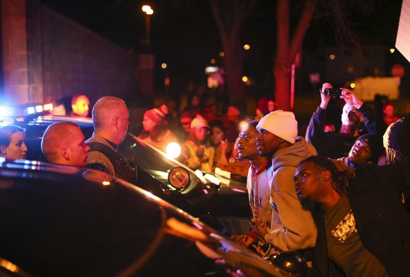Demonstrators confront Minneapolis police officers at the side entrance to the 4th Precinct station, Sunday night, Nov. 15, 2015, in Minneapolis after a man was shot by Minneapolis police early Sunday ...