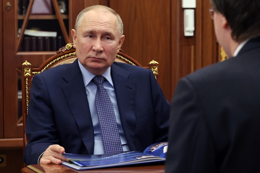 Russian President Vladimir Putin listens to Ruslan Baysarov, Chairman of the Board of Group of companies Bamtonnelstroy-Most, back to a camera, during their meeting at the Kremlin in Moscow, Russia, T ...