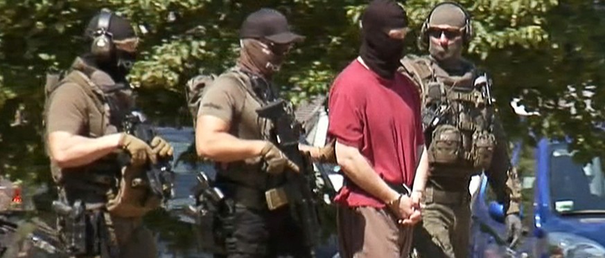 German special police escorts Stephan E., supected of killing the administrative chief of the city of Kassel Walter Luebcke, back to a helicopter after a hearing at the Federal Court in Karlsruhe, Ger ...