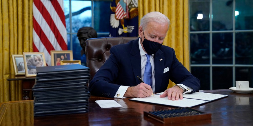 US-Präsident Joe Biden beim Unterzeichnen seiner ersten Anordnung im Oval Office des Weißen Hauses.