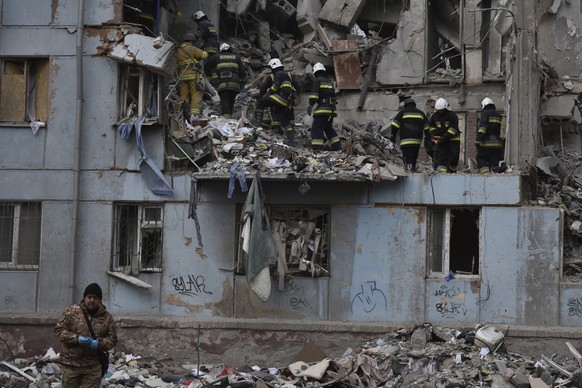 03.03.2023, Ukraine, Saporischja: Feuerwehrleute des staatlichen ukrainischen Katastrophenschutzes inspizieren ein beschädigtes Haus nach einem russischen Raketeneinschlag. Foto: Andriy Andriyenko/AP  ...
