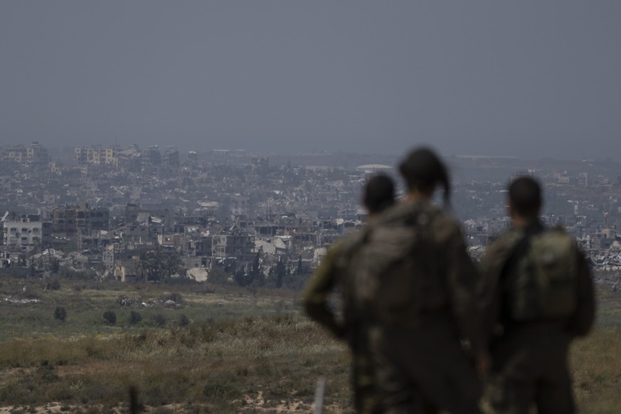 09.04.2024, Israel, ---: Israelische Soldaten betrachten zerstörte Gebäude im Gazastreifen in der Nähe der Grenze zwischen Israel und Gaza. Foto: Leo Correa/AP/dpa +++ dpa-Bildfunk +++