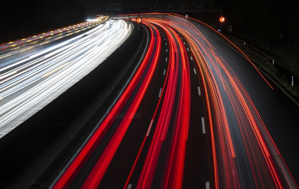 27.09.2022, Hessen, Frankfurt/Main: Vorbeifahrende Autos ziehen in der Dunkelheit ihre Lichtspuren über die Autobahn 5 bei Frankfurt. Auch angesichts anhaltend hoher Treibstoffpreise ist das Interesse ...