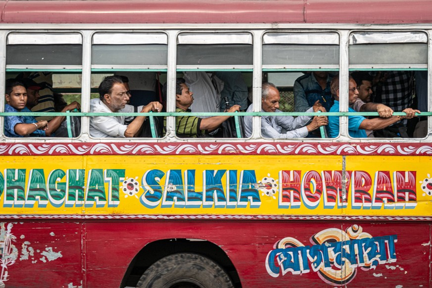 May 23, 2019 - Kolkata, West Bengal, India - Indian men sit on a colorful public bus on the Howrah Bridge in the Bara Bazar, Barabazar Market district, in Kolkata formerly Calcutta, in West Bengal, In ...