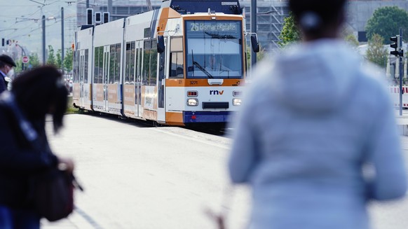 Menschen warten an einer Straßenbahnhaltestelle auf die Ankunft einer Straßenbahn. Viele Menschen haben die testweise eingeführten Gratisfahrten in Bussen und Straßenbahnen in Heidelberg an den vergan ...